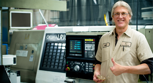 Jim Brey founder of Aztalan Engineering Inc. in front of Okuma cnc machine