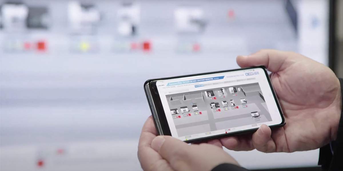 a machine shop owner using Okuma’s Connect Plan on their phone